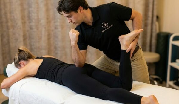 Therapist performing pin and stretch of glute, woman prone Therapist performing pin and stretch of glute, woman prone